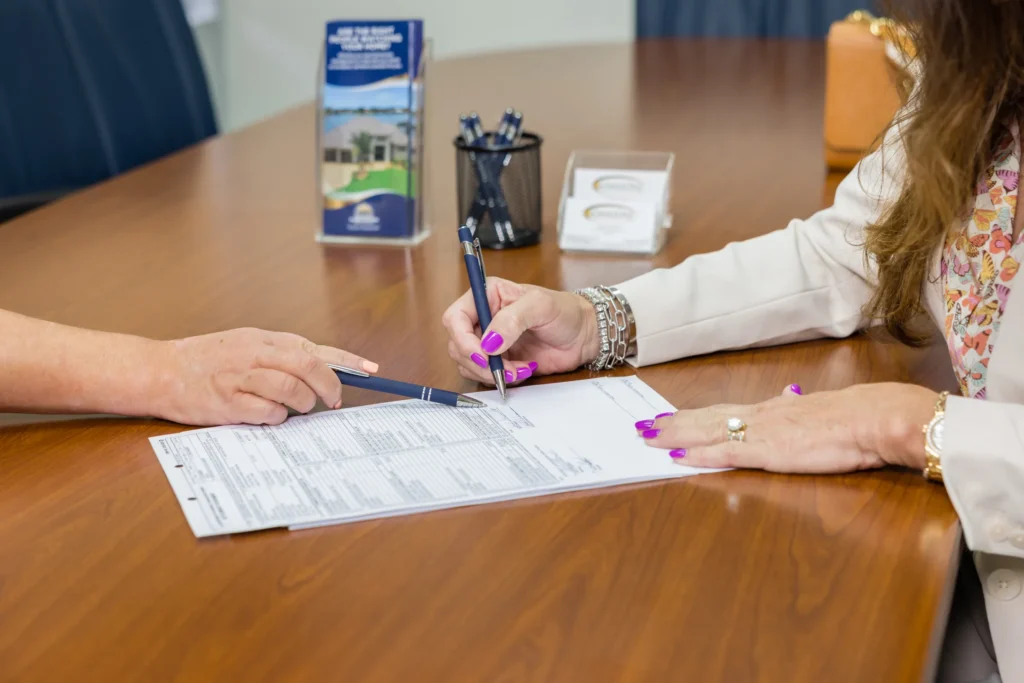 woman signing a paper with pen