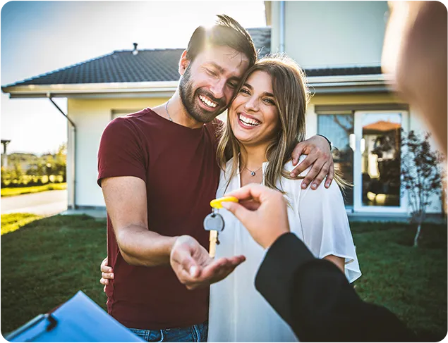 couple smiling with key to home